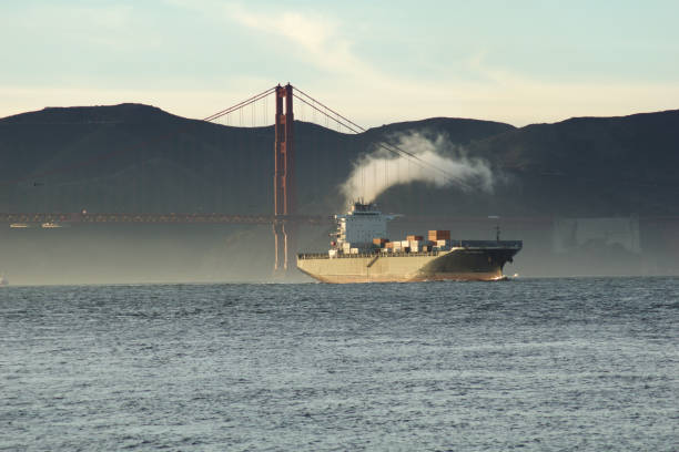 SAN FRANCISCO, CALIFORNIA, UNITED STATES - NOV 25th, 2018: A fast moving cargo container ship, entering San Francisco Bay, sailing underneath the Golden Gate Bridge.