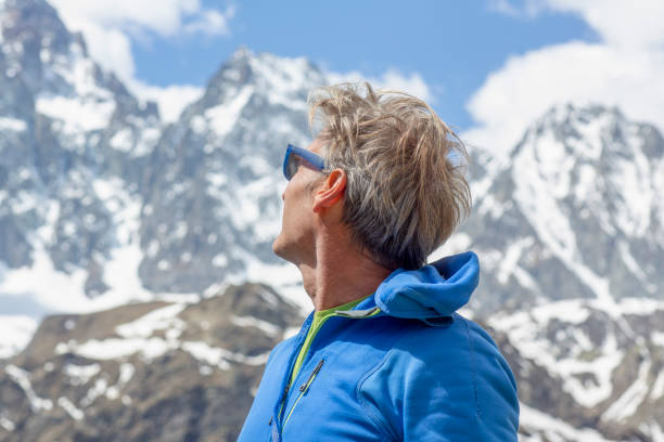istock Mountaineer relaxes on mountain ridge 1280745564