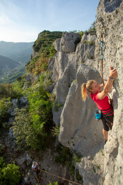 istock Young woman climbs vertical rock ridge 1280745633