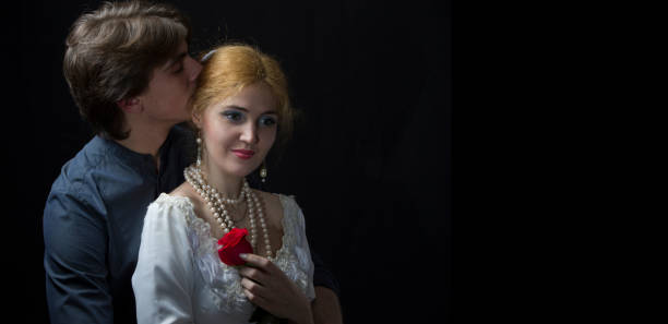Shot of a cheerful young couple holding one another while looking into each other's eyes outside at night