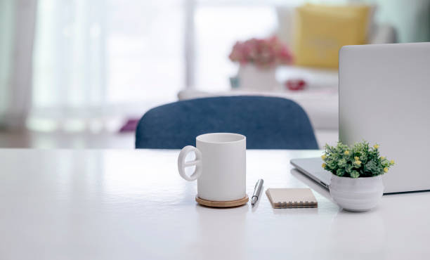 istock Home office concept with white mug and laptop computer on white wooden table, copy space. 1280750289
