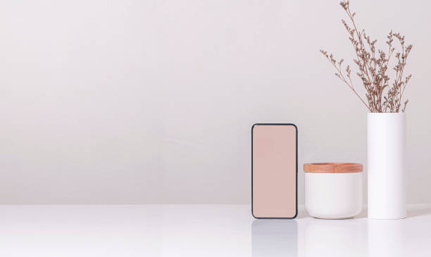 istock Mock up blank screen smartphone and ceramic vase on white teble, copy space. 1280750723