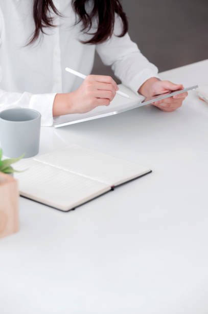 istock Corpped shot of female hands using stylus pen writing on tablet screen while sitting at the table in office. 1280750726