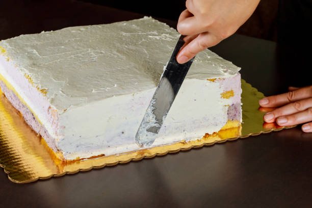 istock Baker covers the cake with white cream. 1280751544