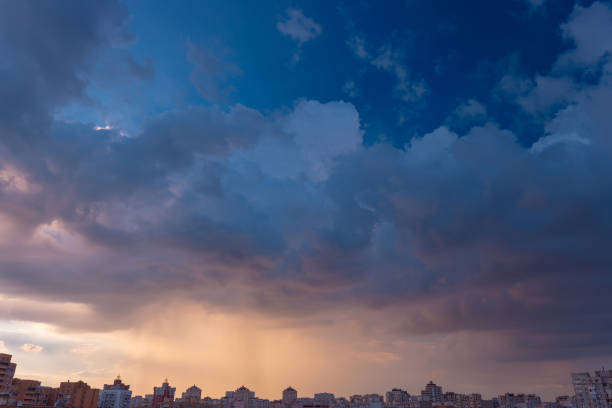 Beautiful sunset sky with rainy clouds over the city. Twilight over the urban district. Typical panorama of a modern residential district. Kyiv. Ukraine.