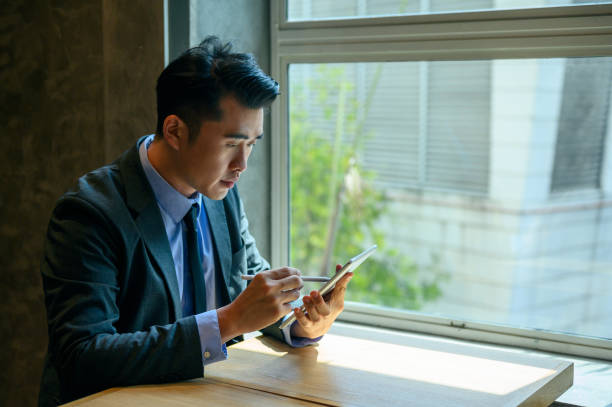 istock Young asian CEO using tablet for business in motion 1280754263