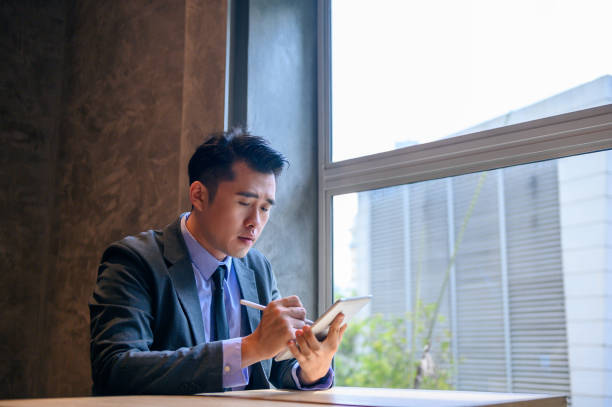 istock Young asian CEO using tablet for business in motion 1280754297