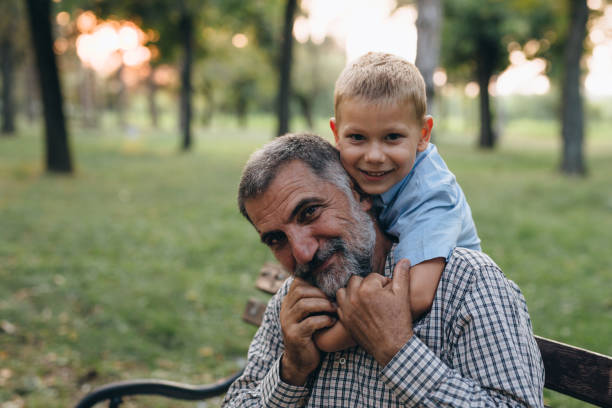 istock little boy having fun with his grandfather in park 1280754681