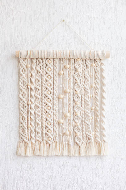 istock Macrame wallhanging with wooden beads. Wall panel of cotton threads in natural color. Macrame technique for eco home decor and wedding decoration. Modern macrame wall hanging will add cozy atmosphere 1280759400
