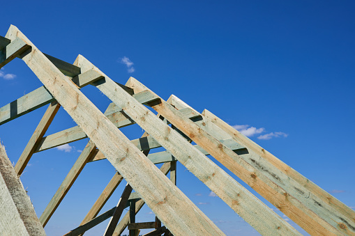 Roof structure on construction site. Wooden Roof Frame. Installation of wooden beams at house construction site