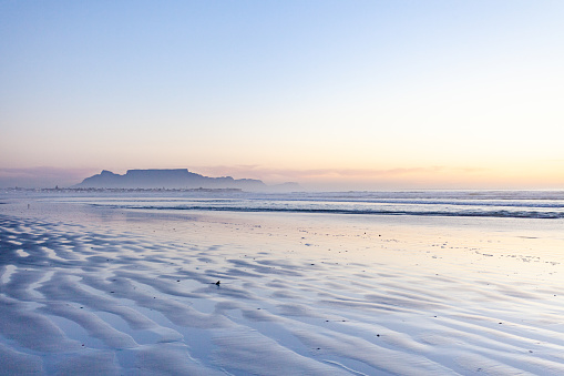 Panoramic view of Table Mountain in Cape Town at dusk. Shows sea, horizon and sky; taken from Melkbosstrand.