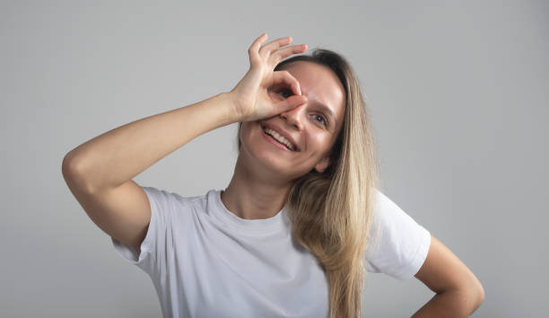 istock Young caucasian woman over grey studio background doing ok gesture like binoculars, eyes looking through fingers. Crazy expression 1280765142