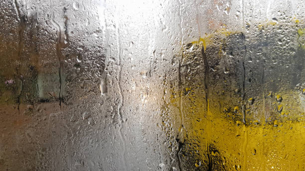 Rain on the rear window of a car in autumn. Inside view of the road with moving cars in the city through the window from the car with rain drops. driving a car in the field of view of the rear window lluvia en la ventana trasera de un coche en otoño. vista interior de la carretera con coches en movimiento en la ciudad a través de la ventana desde el coche con gotas de lluvia. conducir un coche en el campo de visión de la ventana trasera