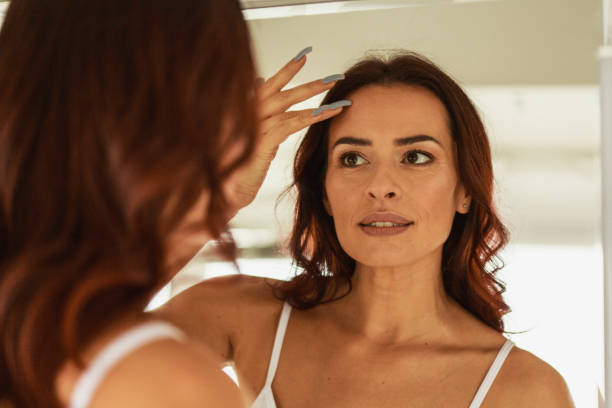istock Woman checking her forehead skin 1280767040