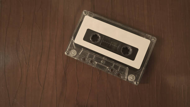 Close-up images of cassette tape on retro wood table. represent nostalgia mood or moment to 80s or 90s that most of audio music or songs recorded in compact and handy device technology. imágenes de primer plano de cinta de casete sobre mesa de madera retro. representan el estado de ánimo de la nostalgia o el momento a los 80 o 90 años que la mayoría de la música de audio o canciones grabadas en la tecnología de dispositivos compacto