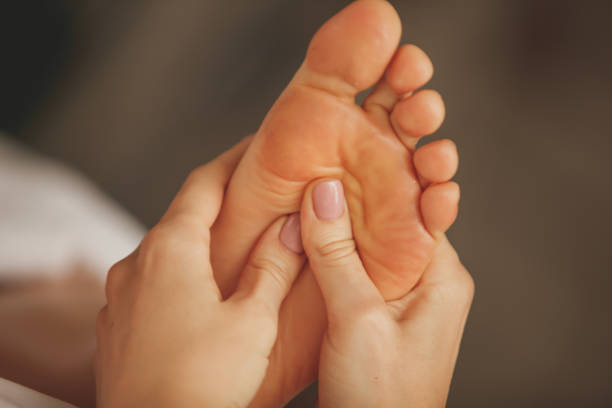 Close up shot of unrecognizable massage therapist relieving pain by doing pressure points onto her client's foot during a massage at the spa.