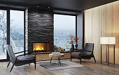 Country villa modern interior living room area with fireplace and black slate stone chimney.