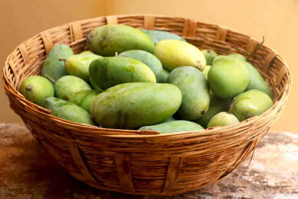 Photo of Bunch of raw mango in traditional basket