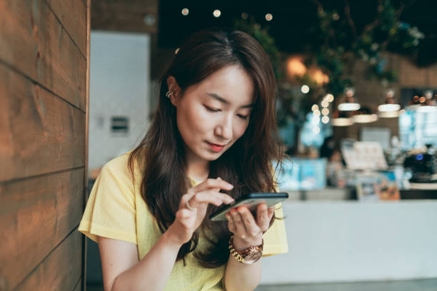 istock Asian woman using smartphone in restaurant 1280771349