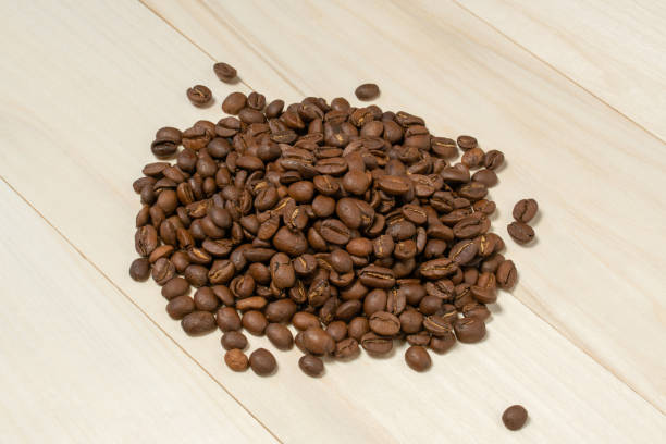 istock coffee beans sprinkled on a wooden table, closeup 1280774230