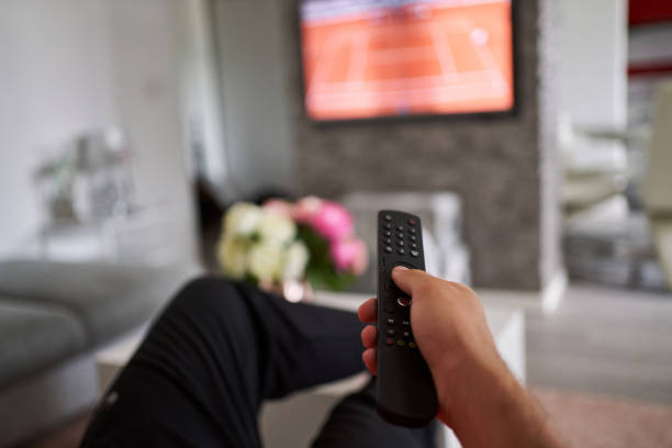istock Close up of mans hand holding a TV remote 1280777637