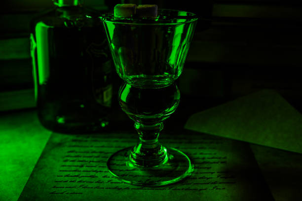 暗い緑の夜��の雰囲気の中で孤立したアブサンガラスとボトルの景色 - liqueur color image isolated nobody ストックフォトと画像