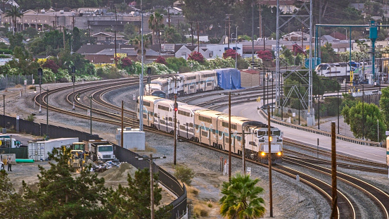 View of a train driving through a city in the early morning light, California, USA.