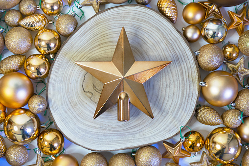 Christmas Golden Star on wooden log and holiday decorations