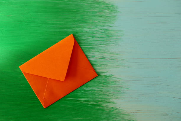 istock Close-up of orange envelope on color background 1280791375