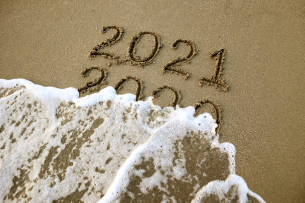 istock New year 2021 and 2020 on sandy beach with waves 1280791917