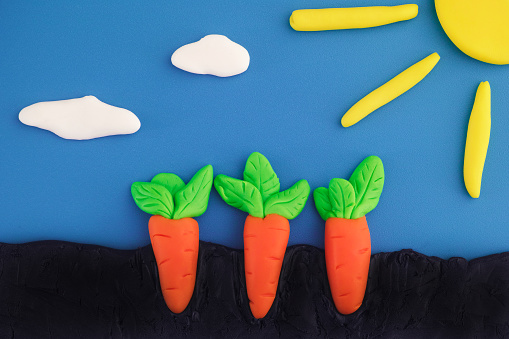 Carrots growing in the ground. The scene is made out of polymer clay.