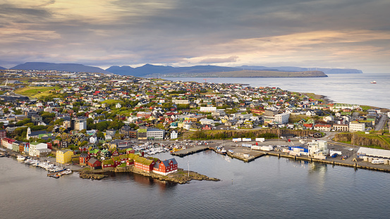 Tórshavn Sunset Waterfront Cityscape Panorama. Aerial Drone Point of View towards the colorful harbor of Torshavn, the capital city of the Faroe Islands. Torshavn, Streymoy Island, Faroe Islands, Kingdom of Denmark, Nordic Countries, Scandinavia, Europe.