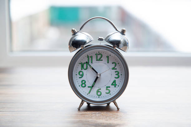 istock Analog alarm clock on the windowsill in the morning. 1280797682