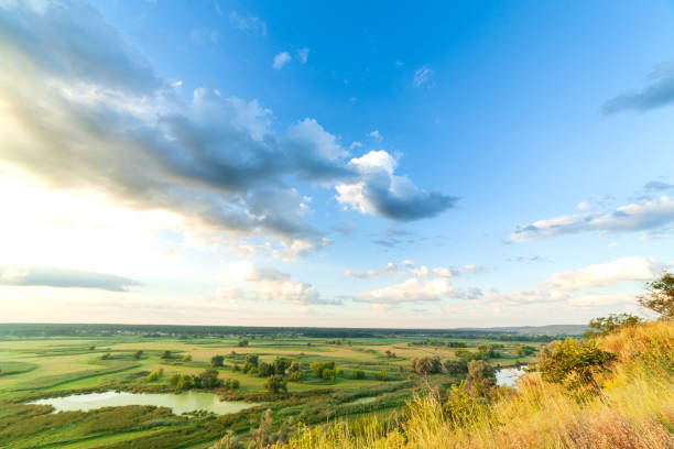 istock A beautiful valley with a river, blue sky with large clouds and bright sun. Aerial 4K UHD 1280797933