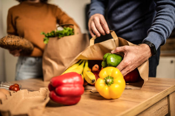 istock Unrecognizable young couple unpacking groceries in the kitchen. 1280800991