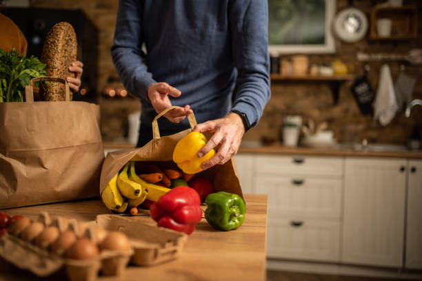 istock Unrecognizable young couple unpacking groceries in the kitchen. 1280800997