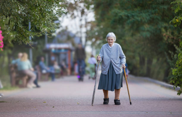 istock Senior woman with canes walking in park 1280803798