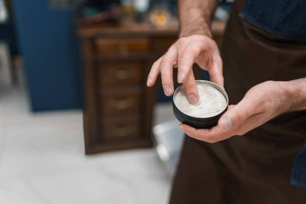 髪のスタイリングにポマードを使用して美容師 - pomade ストックフ��ォトと画像