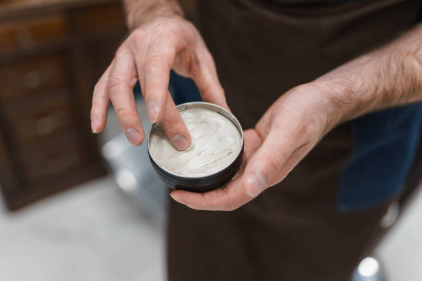 髪のスタイリングにポマードを使用して美容師 - pomade ストックフォトと画像