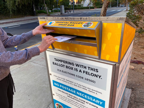 Woman placing vote ballot in official drop box Venice, CA, USA - October 12, 2020: Placing 202 ballot in official drop box ballot box photos stock pictures, royalty-free photos & images