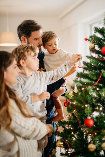 istock Young family decorating christmas tree 1280821273
