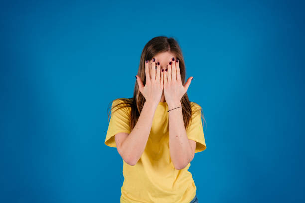 istock Young brunette woman covering face using her both hands over blue background 1280821389