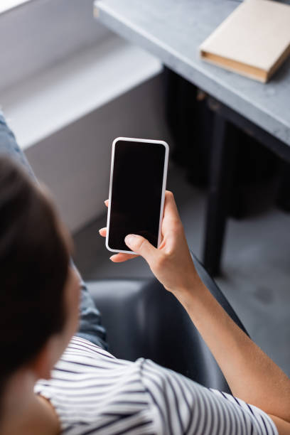 istock Overhead view of young woman using smartphone with blank screen at home 1280821544