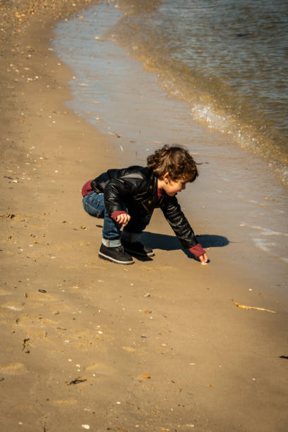 istock Young Boy Bending Over by the Water 1280830385