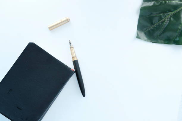 top view of a diary and fountain pen on white background .