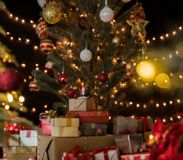 istock Many colorful gift boxes and other christmas decorations under a beautiful decorated christmas tree with bokeh lights in living room 1280835786