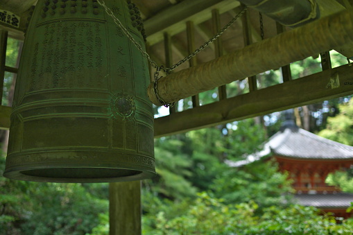 A bell is hanging on the bell tower of a traditional Korean temple.