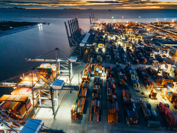 Container ship loading and unloading in deep sea port, Aerial view business commercial trading logistic import and export freight transportation, Container loading cargo freight ship maritime at night carga y descarga de buques portacontenedores en puerto de aguas profundas, visita aérea comercial comercial de importación logística de importación y exportación de transporte de mercancías, buque de carga de carga de carga de carga de carga de carga