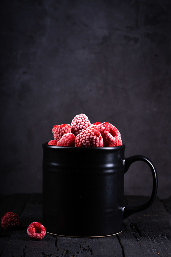Ripe red raspberry on black background