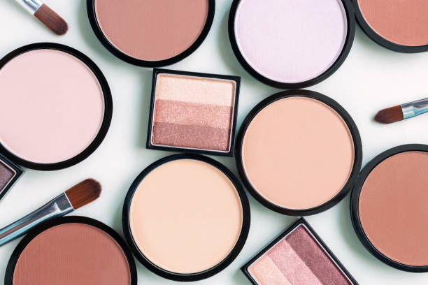 istock Beautiful different beige blush and compact face powders on a delicate mint blue background. Pastel trendy colors matte foundation. Eyeshadow palette. Cosmetics and makeup brushes. Top view, flat lay. 1280854687
